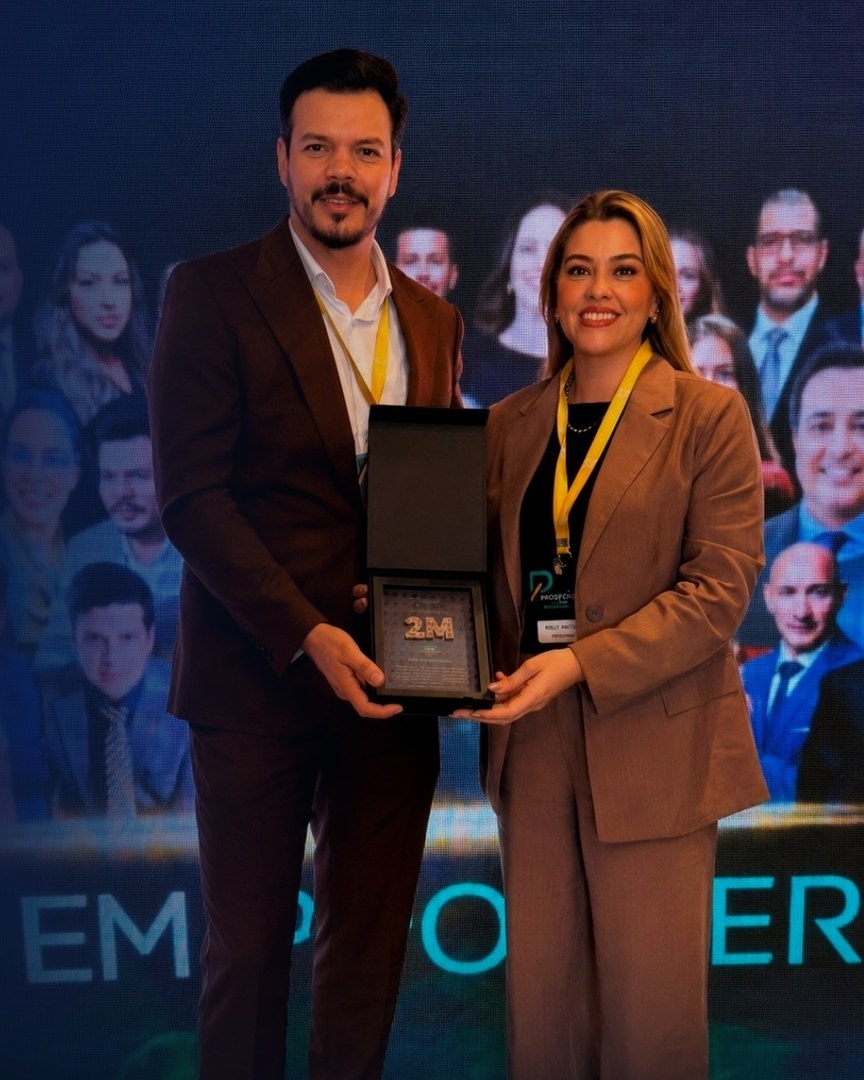 Dr. Cleison Baeve e Kelly Afonso recebendo a placa 2M